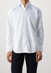 Witte langwerpige overhemd van katoenmix, met een klassieke kraag en knoopmanchetten. Glad textuur met een slim fit.