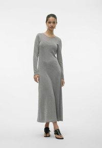 Långärmad, silverstickad klänning med avslappnad passform och rund halsringning, med en mjuk textur och flödande silhuett, som matchas med svarta sandaler.