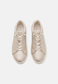 Beige Sneaker mit strukturiertem, metallischem Finish, featuring eine glatte Zehenpartie, kontrastierenden Schnürsenkeln und einem dezenten Logo an der Seite. Größe 37.