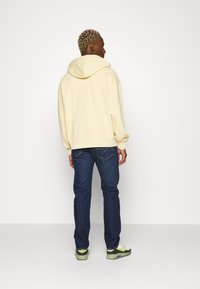Levi's® TAB HOODIE UNISEX - Jersey con capucha - yellow plum