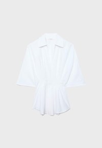 Blouse blanche à manches courtes avec col large et taille cintrée, présentée à plat sur un fond clair.