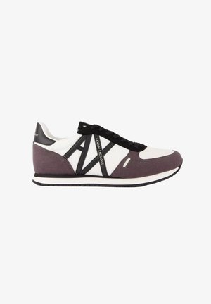 Zapatilla deportiva de perfil bajo en blanco, negro y gris con cordones negros y gran logotipo "AX Armani Exchange" en el lateral.