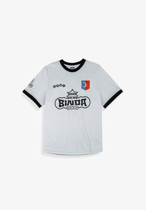 Camiseta blanca de manga corta con cuello y puños negros, con el logo "BINDA BEER", gráfico de pagoda, texto GRMY y un parche de sol y luna en rojo y azul.