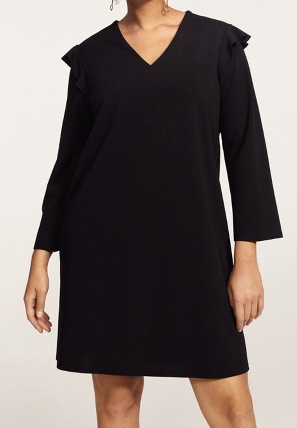 Vestido negro con escote en V, mangas tres cuartos y acentos de volantes en los hombros. Hecho de una tela suave para un ajuste relajado.