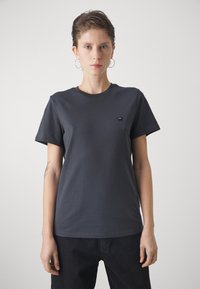Donkergrijze katoenen T-shirt met korte mouwen, ronde halslijn en een klein driehoekig logo op de linkerkant van de borst. Gladde textuur, comfortabele pasvorm.