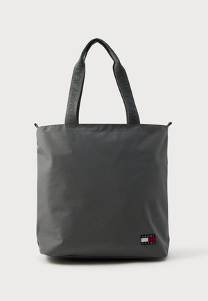 Sac fourre-tout en tissu gris avec de longues poignées arborant la marque "TOMMY JEANS". Fermeture éclair et petite étiquette logo à l'avant.