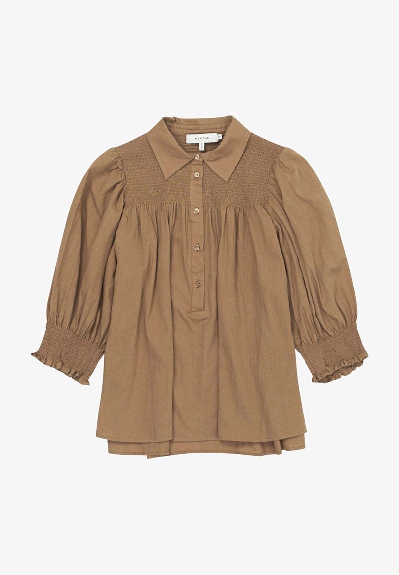 Blouse marron clair à manches longues avec empiècement et poignets smockés, fermeture à boutons à l'avant, tissu froncé et col classique pointu.