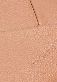 Pelle rosa chiaro testurizzata, con una superficie liscia e una grana sottile, e con il marchio impresso sul lato inferiore destro.