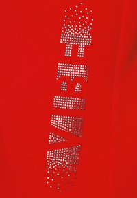 Red fabric with a textured pattern of silver rhinestones arranged in a stylized graphic design, featuring various geometric shapes.