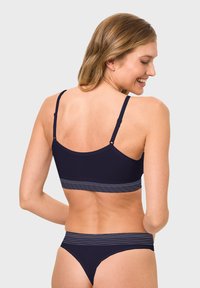 Navy-Bikini-Set mit einem einfarbigen Oberteil mit verstellbaren Trägern und einem gestreiften Bund, kombiniert mit passenden tief sitzenden Bottoms. Glatte Textur.