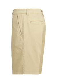 Beige cotton shorts with a straight cut, featuring side pockets, a rear welt pocket, and visible stitching along the seams.