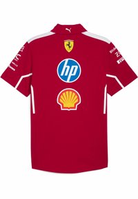 Tricou roșu Puma cu mâneci scurte, având accente albe. Logourile include Ferrari, HP și Shell, fiind vizibile pe spate. Material moale.