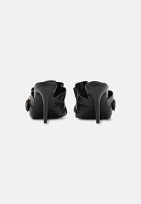 Zwarte leren hoge hakken met een ronde neus, met geplooide details aan de achterkant en een slanke stilettohak.