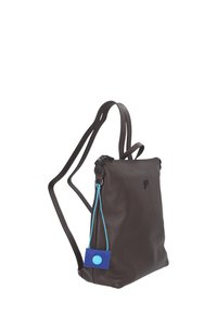 Zaino in pelle marrone con cinghie regolabili, cerniera superiore e una targhetta blu appesa al lato. Superficie testurizzata e design minimalista.