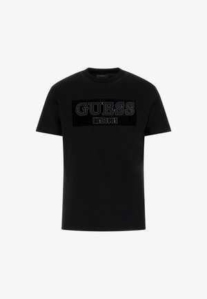 Zwarte katoenen t-shirt met een groot, textuur GUESS-logo met "EST. 1981" eronder, ronde hals en korte mouwen.