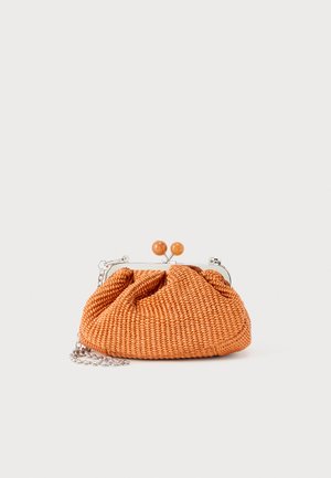 Kleine oranje geweven clutch met zilverkleurig metalen frame, ronde sluiting en een zilveren kettingriem op een witte achtergrond.