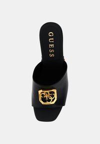 Infradito neri con fibbia dorata del logo Guess sul cinturino e soletta firmata, punta quadrata e design con tacco aperto.