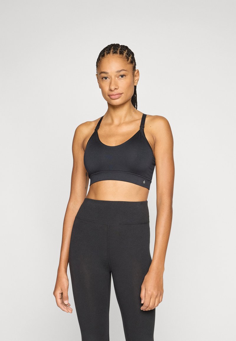 Top desportivo preto com alças ajustáveis e decote redondo, combinado com leggings pretas de cintura alta, ambos feitos de tecido liso e elástico.