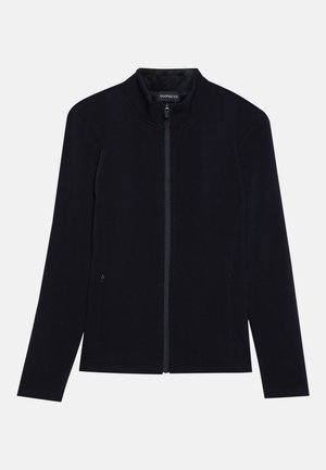 Svart hettejakke med høy krage, laget av myk stoff. Har to sidelommer og en jevn, ensartet tekstur. Enkelt design.