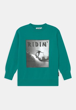 Sweatshirt teal avec un graphique noir et blanc d'un skateur portant le mot "Ridin'" bien en vue. Tissu doux et texturé.