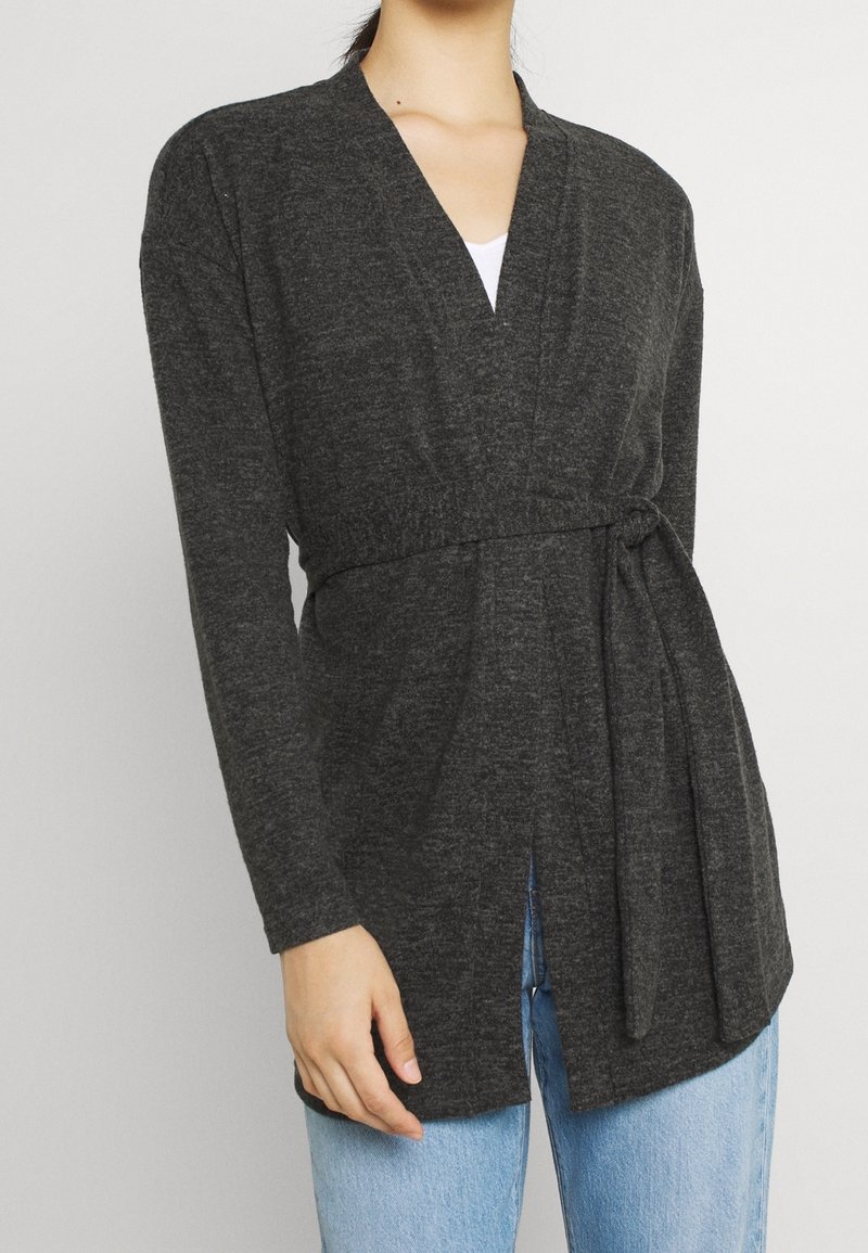 Långärmad cardigan i mörkgrått stickat tyg, med V-ringning, knytbälte i midjan och öppen framsida. Avslappnad passform.