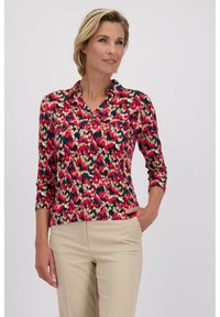 Langsleeve v-hals shirt in een meerkleurig, abstract patroon van roze, groen en beige, met een knoopsluiting en een zacht, textuurstof.