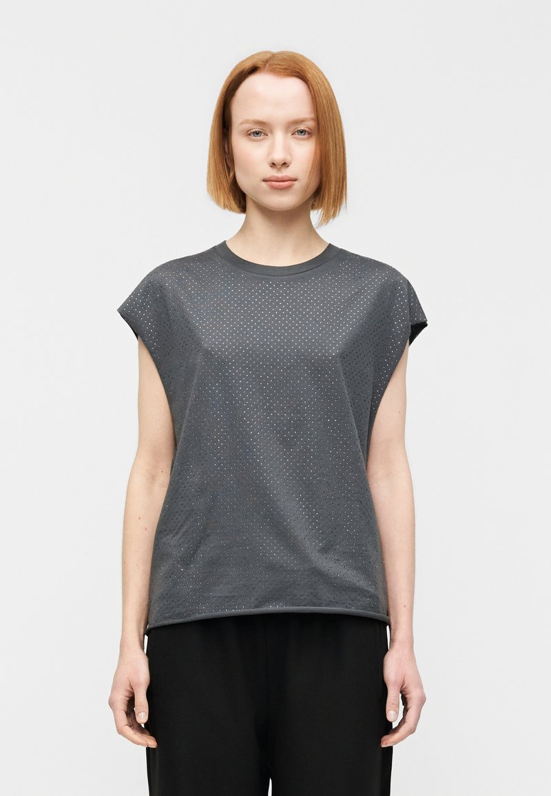 Γκρι κοντομάνικο πουκάμισο με διάτρητη υφή, στρο γγυλή λαιμόκοψη και άνετη εφαρμογή, συνδυασμένο με μαύρο παντελόνι. Απλός σχεδιασμός, καθημερινό στυλ.