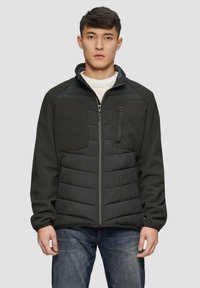 Schwarz gep padded Jacke mit einem Reißverschluss vorne, grauen Fleeceärmeln, zwei Brusttaschen und einem Stehkragen. Auffällige gesteppten Struktur am Körper.