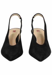 Zapatos de ante negro tipo slingback con un diseño de punta afilada. Presentan un corte en la parte superior y un tacón delgado. La plantilla muestra un logo cuadrado rojo.