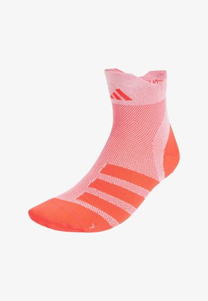 Calcetín de tobillo en coral brillante con paneles de malla texturizada, puntera sólida y tres rayas blancas en el lateral. Fabricado con tejido elástico y transpirable.