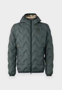 Padded jacket in dark green with a hood, featuring a zip closure, chevron quilting, and elastic cuffs. Lined with a contrasting beige material.
