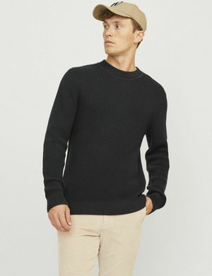 Maglione nero a maglia con un motivo testurizzato, scollo rotondo e polsini aderenti. Indossato con pantaloni in corduroy chiari e un berretto beige.