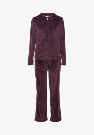 Ensemble de sport en velours bordeaux avec une veste à capuche zippée, cordon de serrage et manches longues ; le pantalon présente une coupe droite et une texture de tissu assortie.