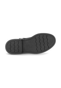 Zool van zwarte schoen met golfpatroon, lichte hak en het merk "Gabor" in reliëf op het gripgedeelte.