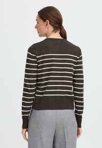 Brun og kremstripet genser med lange ermer, rund hals og ribbestrikket nederkant. Glatt tekstur, tettsittende silhuett og minimalistisk design.