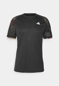 Camiseta deportiva negra de manga corta, con acentos de malla en patrones multicolores en los hombros y un logo blanco en el pecho.