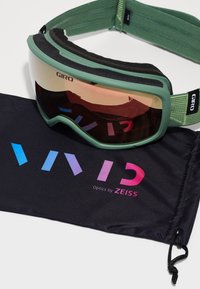 Giro slidinėjimo akiniai su žaliu rėmu, veidrodiniu lęšiu ir minkštu putų pamušalu. Komplekte yra juodas maišelis su užrašais "VIVID Optics by ZEISS" spalvingomis raidėmis.