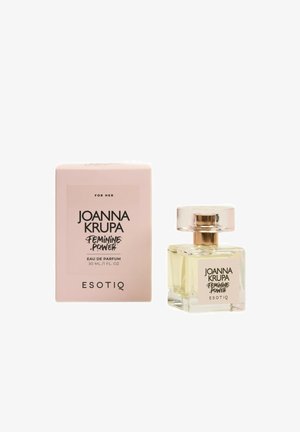 Szklana butelka perfum w kształcie kwadratu, z przezroczystą cieczą i okrągłą srebrną nakrętką. Różowe pudełko oznaczone "Joanna Krupa Feminine Power", 30 mL.