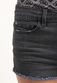 Pantalones cortos de mezclilla oscura con dobladillo deshilachado, diseño de cinco bolsillos, ligera elasticidad y un corte ajustado. Cuenta con un botón superior y cierre de cremallera.