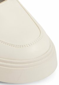 Witte leren sneaker met een ronde neus, voorzien van een gladde textuur, gestikte details en een chunky zoolontwerp.