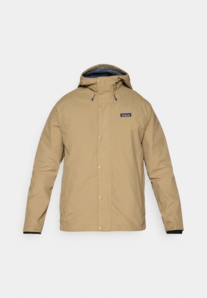Beige nepremočljiva jakna s kapuco, s pritrdilnimi gumbi in črno notranjo podlogo. Ima logotip na levem prsnem delu in nastavljive manšete.