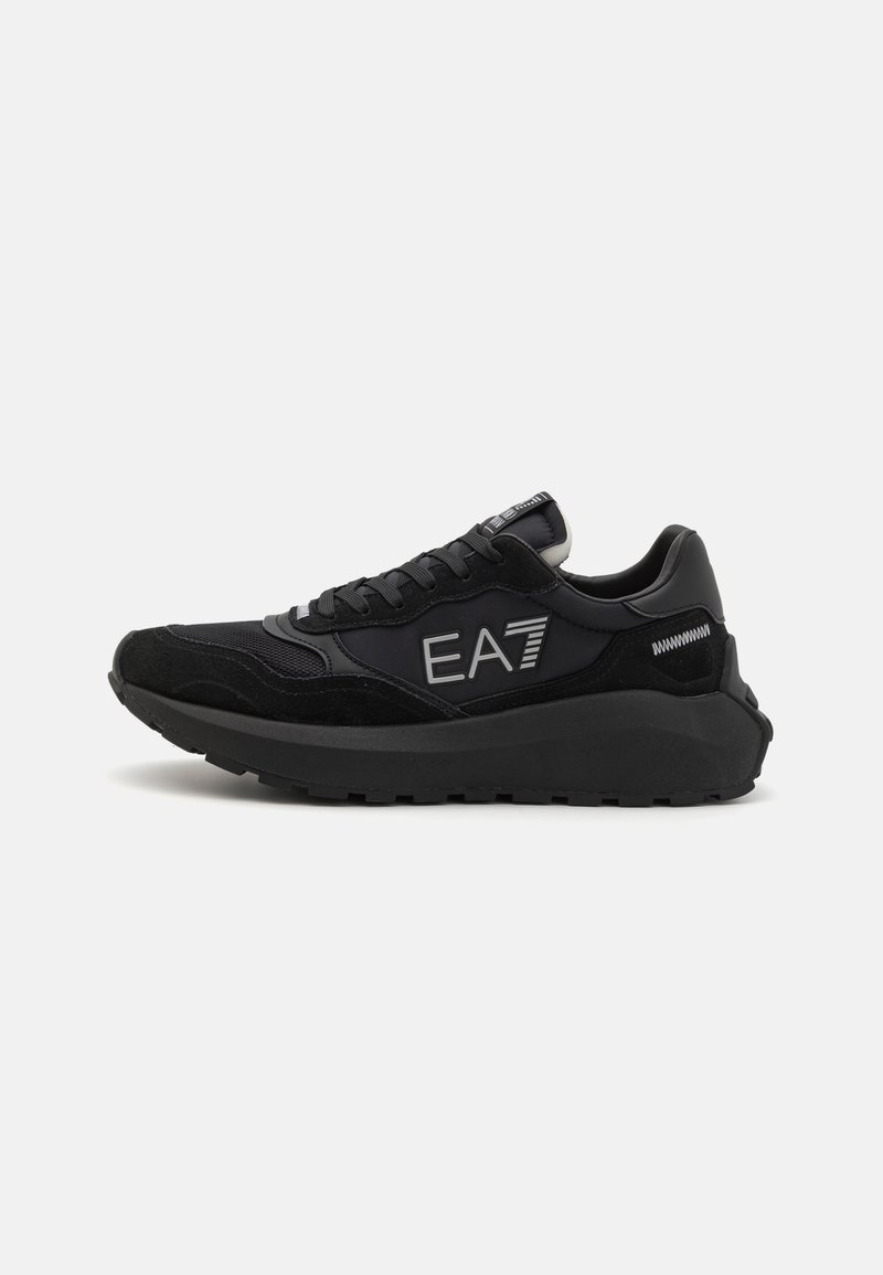 Baskets de sport noires avec un mélange de daim et de matériaux synthétiques, une semelle texturée et un logo EA7 bien en vue sur le côté.