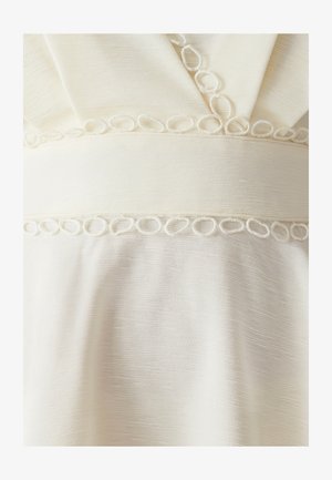 Kleid in knielanger Länge aus weichem, strukturiertem cremefarbenem Stoff mit einem gewebten Taillenband und geschlungenen Details, ausgestattet mit einem V-Ausschnitt und drapiertem Design.