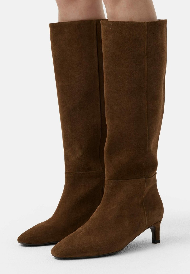 Brown suede knee-high boots with a tapered toe, slim heel, and a smooth texture. Minimalist design with no visible accents.