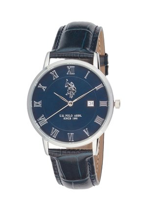 Montre-bracelet ronde avec bracelet en cuir noir, cadran bleu, chiffres romains argentés, guichet date et logo U.S. Polo Assn. avec cheval et cavalier.