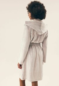 Szara, miękka szlafrok z kapturem, z paskiem w talii, długimi rękawami i teksturowanym wykończeniem. Projekt zawiera detal szwu na plecach.
