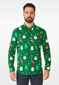 Camicia a maniche lunghe verde con stampa festiva che raffigura volti di Babbo Natale, alberi di Natale, ornamenti e stelle. Realizzata in tessuto morbido e leggero.