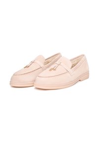 Lichtbeige moccasin instappers van zacht suede, met gouden hardware accenten en een gestructureerde afwerking op de bovenkant en de zool.