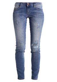 Jean slim bleu clair avec détails déchirés aux cuisses et aux genoux, fermeture par boutons et design à cinq poches.