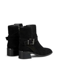 Stivaletti neri in suede con fibbia in metallo lucido e dettagli con cinturino. Presentano un tacco a blocco e una zip sul lato per una facile vestibilità.